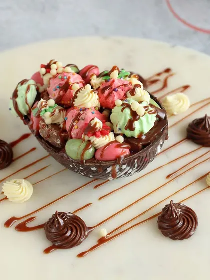 Celebrate Easter in style with our delicious chocolate eggs. This one is a chocolate shell filled with colorful mini macarons and meringues, drizzled with more chocolate.