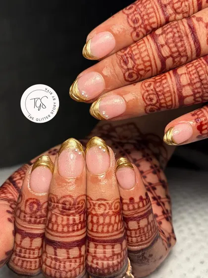 Classic and clean bridal nails. A simple gold chrome French tip is an elegant and timeless choice that beautifully complements traditional wedding henna.