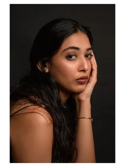A close-up beauty portrait with a focus on natural skin texture and a warm, gentle expression. The lighting is soft and flattering, creating an intimate and engaging image.
