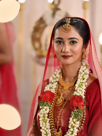 A close-up of the bride's muhurtham look. Her makeup is flawless, with a focus on her eyes and a rich red lip.