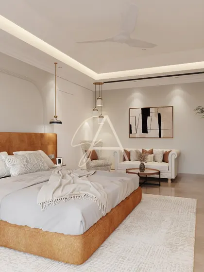 This spacious bedroom includes a separate seating area, making it a true retreat. The design uses a consistent palette of warm neutrals and natural textures to create a cohesive and tranquil environment.