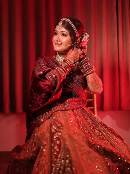A full-length shot capturing the bride's regal presence. The rich velvet lehenga and perfectly draped dupatta create a look of timeless beauty.