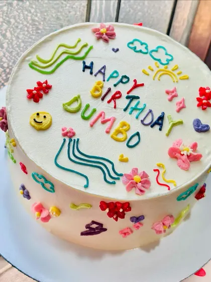 Holding up the custom doodle art cake. The design wraps all the way around the cake, making every angle a feast for the eyes.