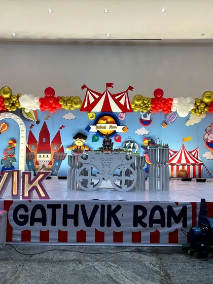 A full view of the red, white, and gold carnival stage, showing the complete arrangement of backdrops, props, and marquee letters.