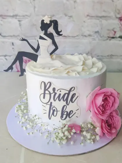An elegant "Bride to be" cake featuring a silhouette topper and fresh pink roses. This is one of our popular non-fondant designs, perfect for a chic bachelorette party.