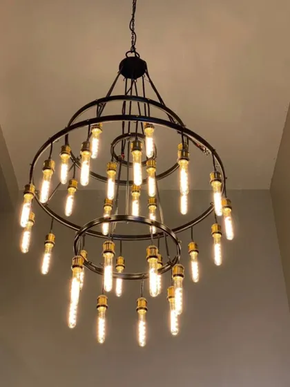 Lighting can define a workspace. This stunning two-tiered chandelier with Edison bulbs serves as a focal point in a corporate lobby, providing both ample light and a dose of modern industrial style.