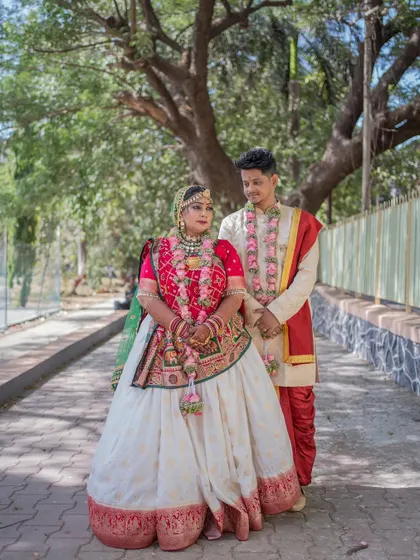 A beautiful portrait of the couple, Manali and Omkar, in their traditional Gujarati wedding attire.