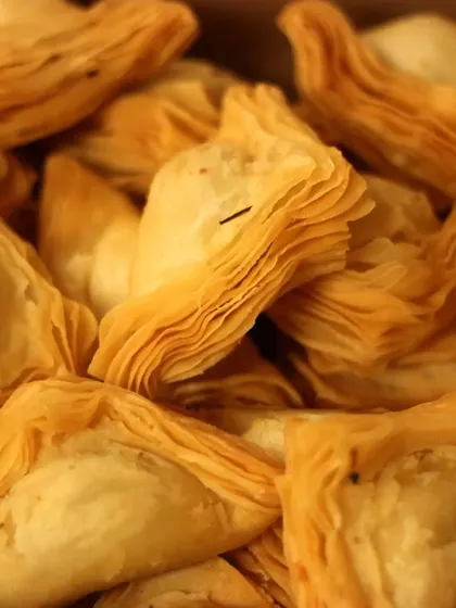 A close up of our signature warkhi samosas. The delicate, flaky pastry is a family specialty, and we offer them with mutton, chicken, or vegetable fillings for any occasion.