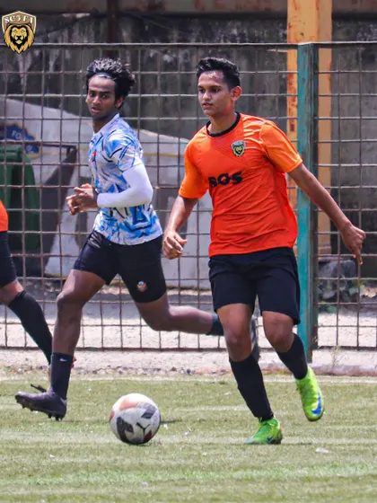 A player advancing the ball in an MFA First Division match. Our training focuses on dynamic movement and attacking play.
