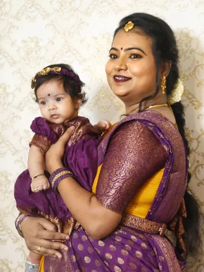 It was a joy to doll up this new mom for her daughter's naming ceremony. The makeup is kept bright and celebratory, with a bold lip to match her vibrant purple and yellow saree.