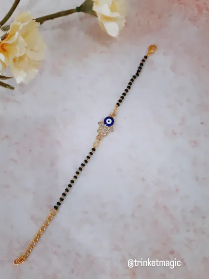 This design combines two powerful symbols: the Hamsa hand and the evil eye. It's a beautiful and meaningful piece, set on a classic mangalsutra-style bracelet.