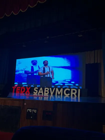 A view of the stage and screen setup for my TEDx talk. A professional setup with clear visuals is essential for supporting the narrative of my performance and engaging the audience on multiple levels.