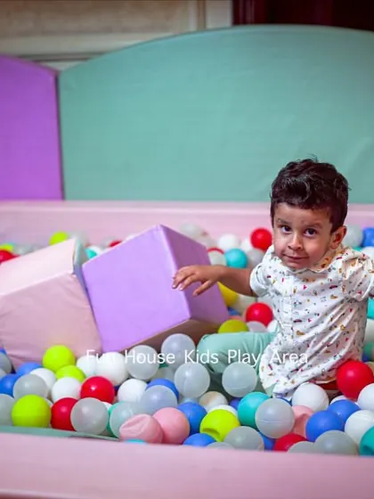 A candid moment of pure fun in our pastel-themed ball pit. We make sure every play area is filled with opportunities for laughter and play, using clean, multi-colored balls for extra excitement.