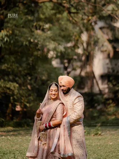 An intimate portrait capturing the couple's gentle embrace. The soft light and natural background highlight their connection and pastel wedding outfits.