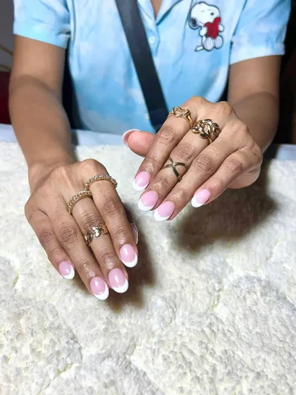 A classic French manicure on short, natural-looking nails. This shows that extensions can be used to create a very subtle and clean look.