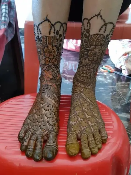 This traditional foot design includes a beautiful scalloped border at the ankle and dense patterns covering the rest of the foot.