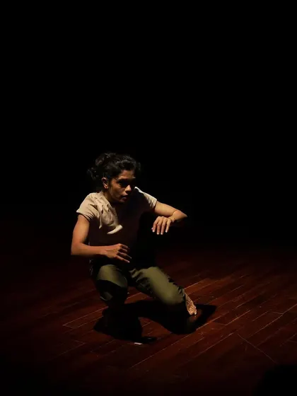 The interplay of light and shadow highlights the form of a contemporary dancer on our stage.