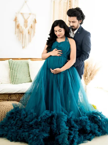 A full-length portrait showcasing one of our popular ruffled maternity gowns. We pose couples to highlight the beautiful baby bump and the connection between the parents-to-be.