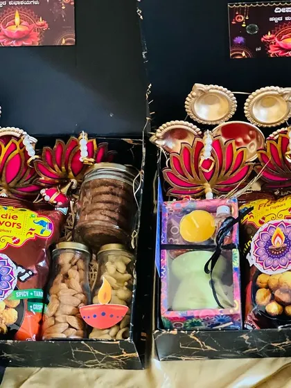 The same elegant black Diwali gift boxes, showing the consistent arrangement of festive items.