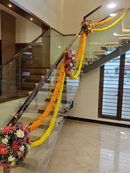 For a housewarming party, we decorated the staircase with traditional marigold garlands and floral bouquets, adding a touch of festive color throughout the home.