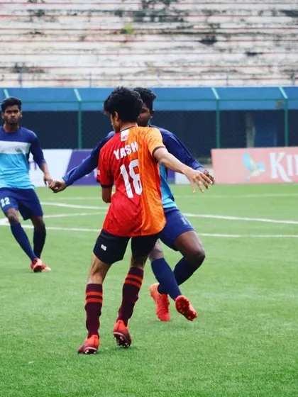 A young player from our senior team skillfully maneuvering the ball against opponents. I blend youth and experience to create a dynamic squad.