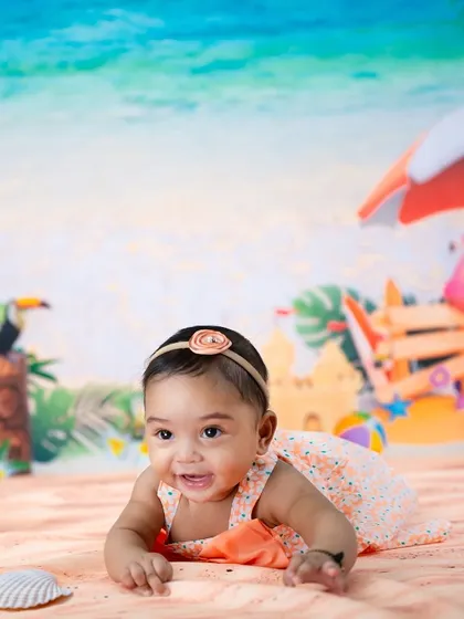 A happy beach baby crawling towards the shore. The bright, cheerful colors of this setup are perfect for a milestone celebration.