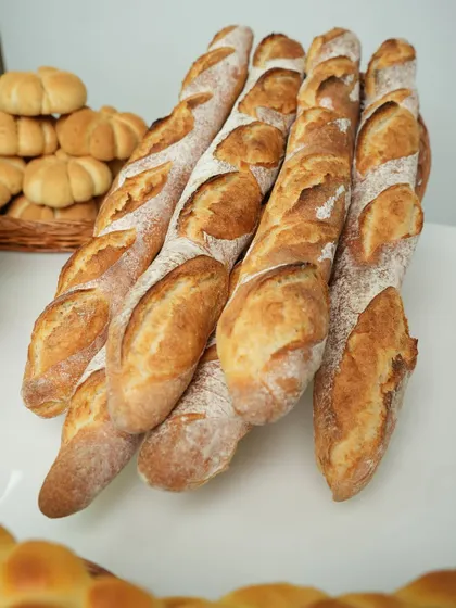 A beautiful lineup of freshly baked baguettes. Mastering this classic French bread, with its crisp crust and open crumb, is a key skill for any professional baker.