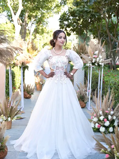 A carnival bridal look in a stunning white gown. The makeup is fresh and elegant, with a simple updo, perfect for a fun, themed event.