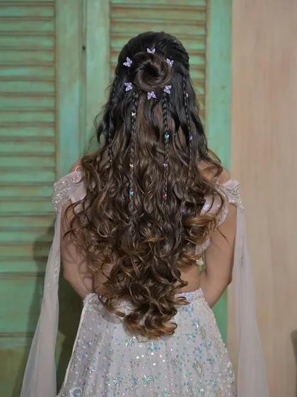 This view highlights the structure of the half-up bun and the placement of the butterfly clips. It’s all in the details, and we focus on teaching precision and artistry in every style.