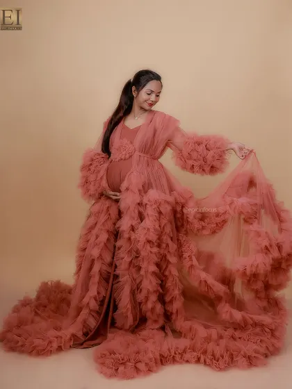 A dramatic pose in a dusty rose ruffled gown, showing off its incredible volume and texture in the studio.