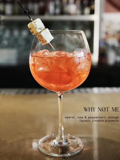 The 'Why Not Me?' cocktail, a beautiful Aperol spritz with rose, peppercorn, and prosecco.