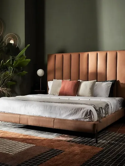 A statement bed with a tall, channel-tufted leather headboard. This piece brings a sense of grandeur and opulence to the bedroom, transforming it into a truly luxurious retreat.