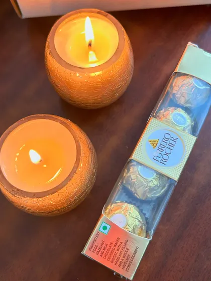 The contents of the mini Diwali hamper outside the box: two scented candles and a pack of Ferrero Rocher. A simple and sweet gift.