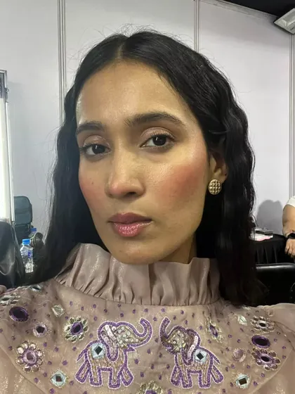 A close-up of the blush draping look on the model. The skin is dewy and fresh, and the lips are glossy, creating a youthful and radiant appearance.