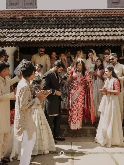 The grand entrance of the couple, welcomed by cheering family and friends, capturing the collective joy of the wedding.