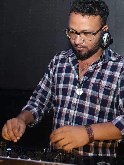 A clear shot of me working the controls, with a drink nearby. A DJ's work is a balance of focus and enjoying the party atmosphere.