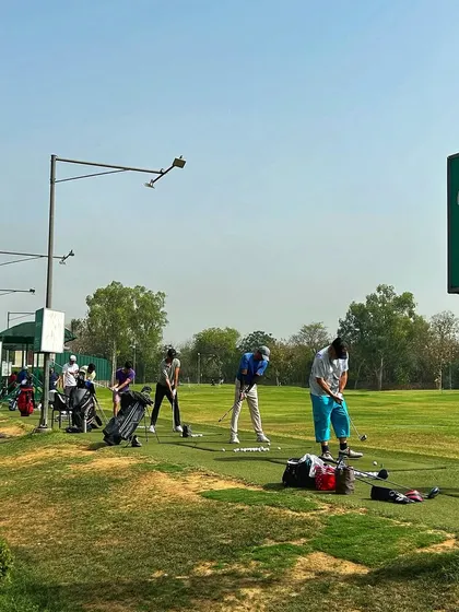 A clear view of the driving range with the Hamoni sign, showing players enjoying a Sunday session.