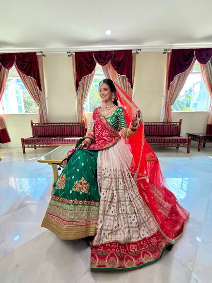 A full-length view of a traditional Gujarati bride, showcasing her unique Panetar saree and how the makeup complements the vibrant colors.