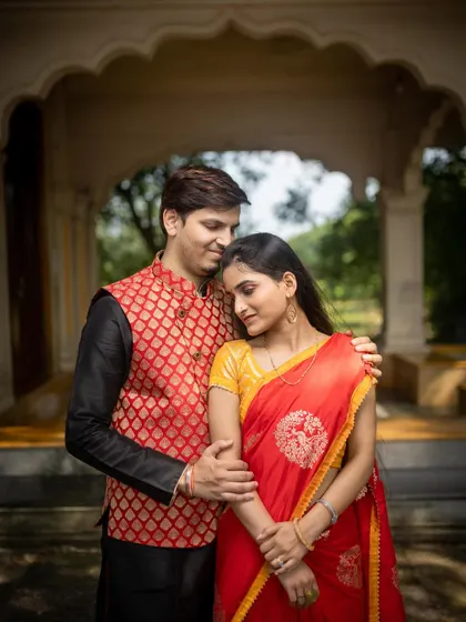 A close, intimate portrait of a couple in traditional wear. The groom's embrace and the bride's serene expression make for a deeply romantic photograph.