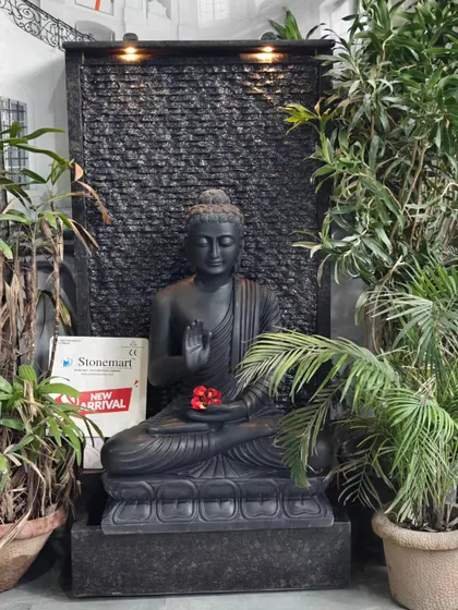 Another angle of the 3-foot black marble Buddha set against the 5-foot granite waterfall, showing how the integrated lights create a warm ambiance.