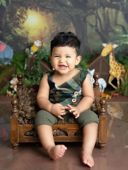 A cheeky grin from the king of the jungle! This baby boy looks right at home on his little wooden bed in our lush, animal-filled jungle setup.