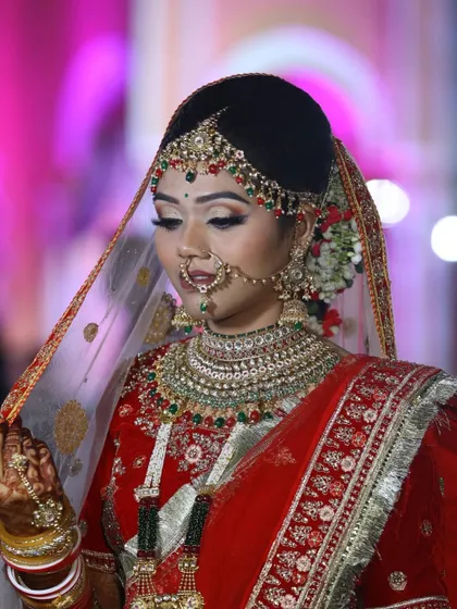 Our live bride looking radiant in her red attire. The makeup features a classic winged liner and bold lip, perfectly complementing the heavy jewelry and intricate outfit for her wedding day.