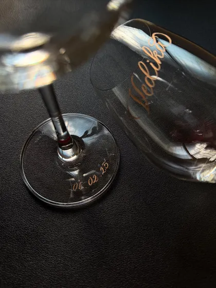 A close-up of the base of a wine glass, engraved with a special date. It's a subtle yet meaningful way to commemorate an important milestone.