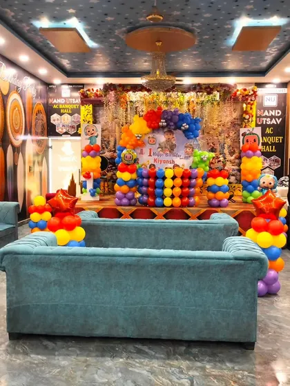 A wider view of the Cocomelon themed birthday party, showing the stage decoration and the seating arrangement in the banquet hall. I ensure the entire venue feels like part of the celebration.