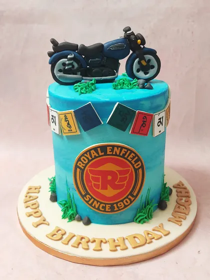 We capture the spirit of the open road with this Royal Enfield themed cake. A detailed fondant motorcycle sits atop a cake featuring the brand's logo and prayer flags, evoking a sense of adventure perfect for a biker's birthday.