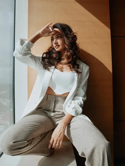 Another angle of Shanvi Srivastava's chic white blazer look. The natural light from the window highlights the clean lines and neutral tones of the outfit.
