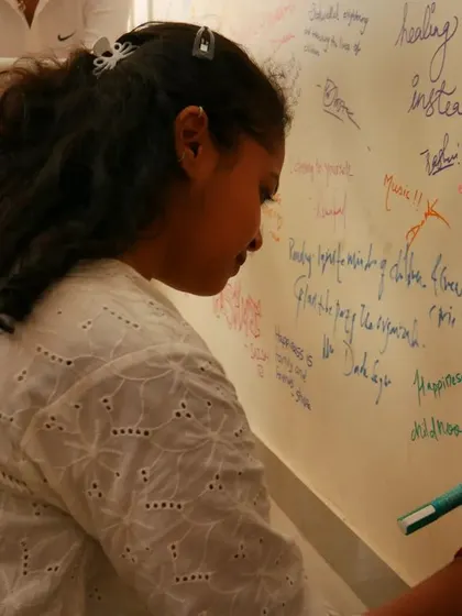 A volunteer writes on the "Happiness Wall," a tradition at our office bonding events.