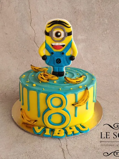 This Minion cake is all about the details. The 1 kg Vanilla Chocolate cake has a perfect buttercream finish, a ganache drip, and a 2D fondant Minion surrounded by tiny fondant bananas.