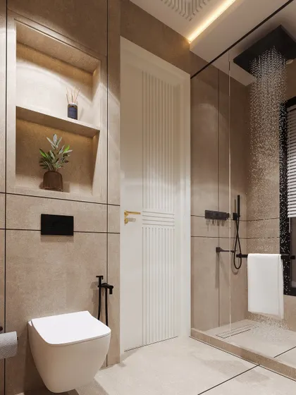 A view of the shower and toilet area, showing the cohesive use of beige tiles and matte black fixtures for a modern, understated look.