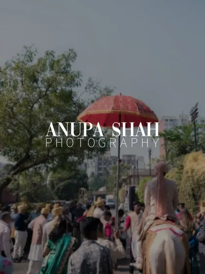 An atmospheric shot of the Baraat procession, with the groom on his horse under a traditional red umbrella, creating a sense of scale and excitement.